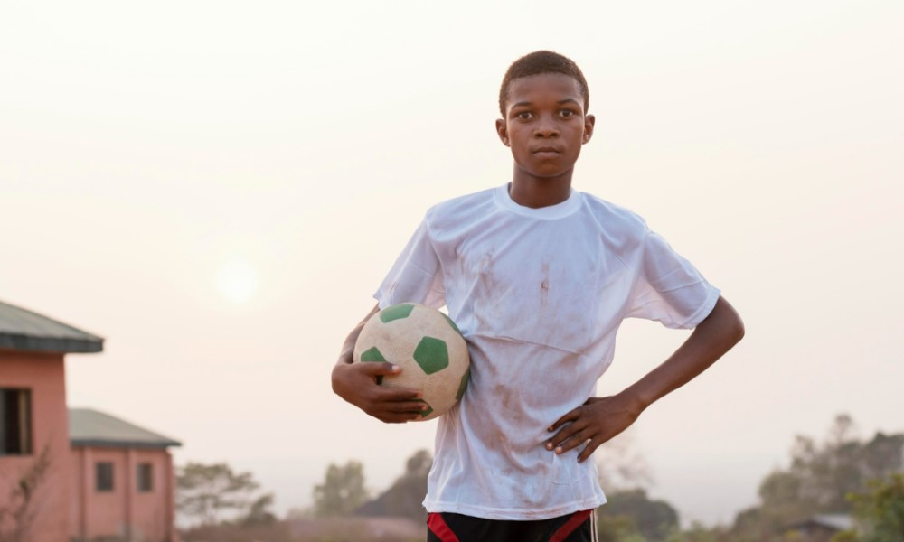 foto de um garoto segurando uma bola